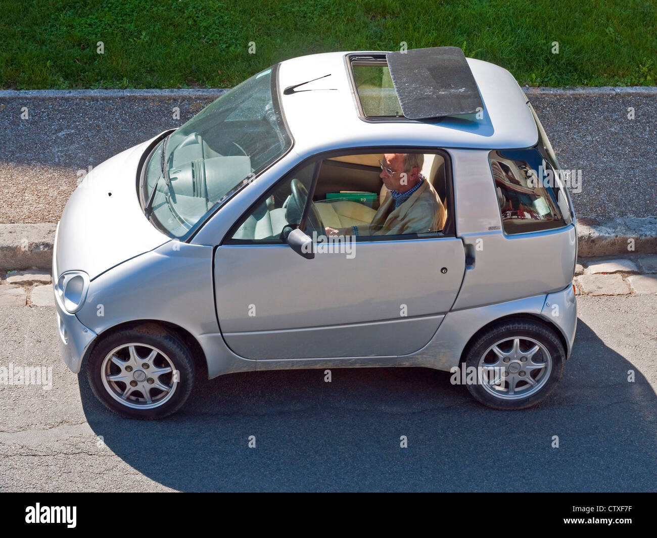 Man parking small car (used by drivers without license after drink driving convictions) - France. Stock Photo