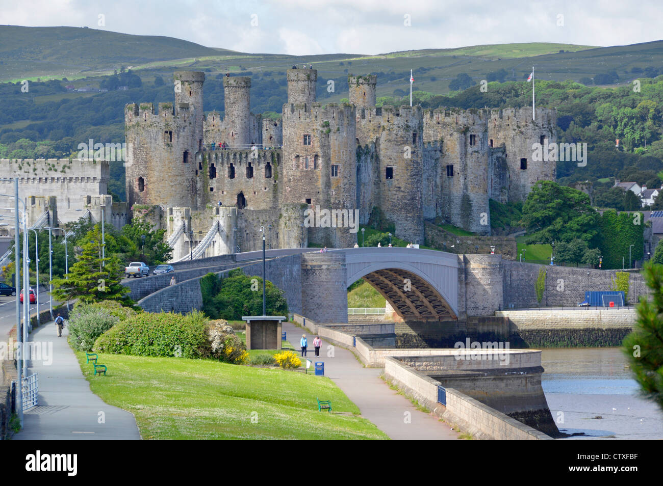 Medieval Conwy Castle a UNESCO World Heritage Site with modern road bridge crossing the River Conwy Welsh hilly countryside beyond in North Wales UK Stock Photo