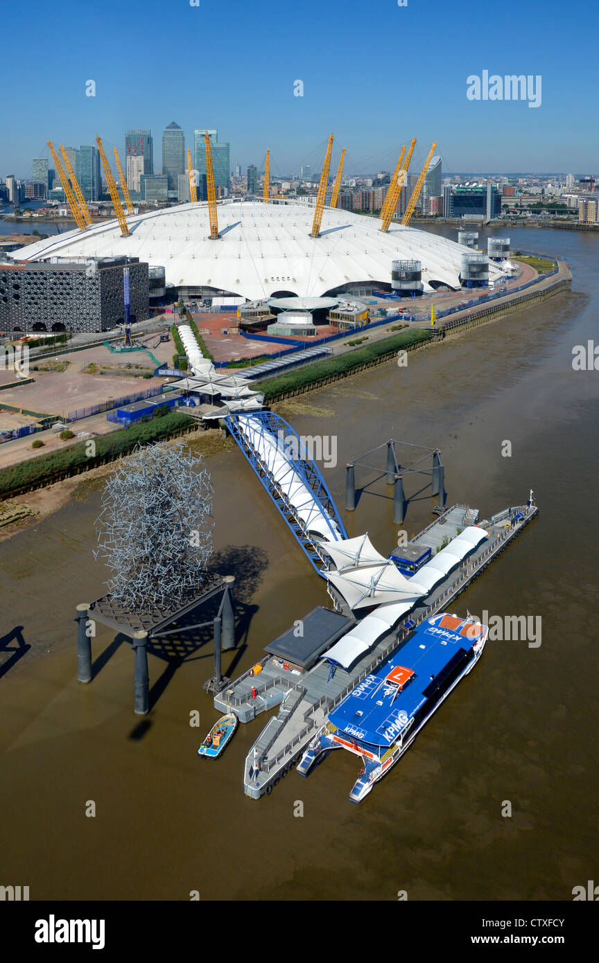 Aerial view of North Greenwich Peninsula & Pier Thames Clipper river bus beside O2 arena millenium dome 2000 & Canary Wharf skyline beyond London UK Stock Photo