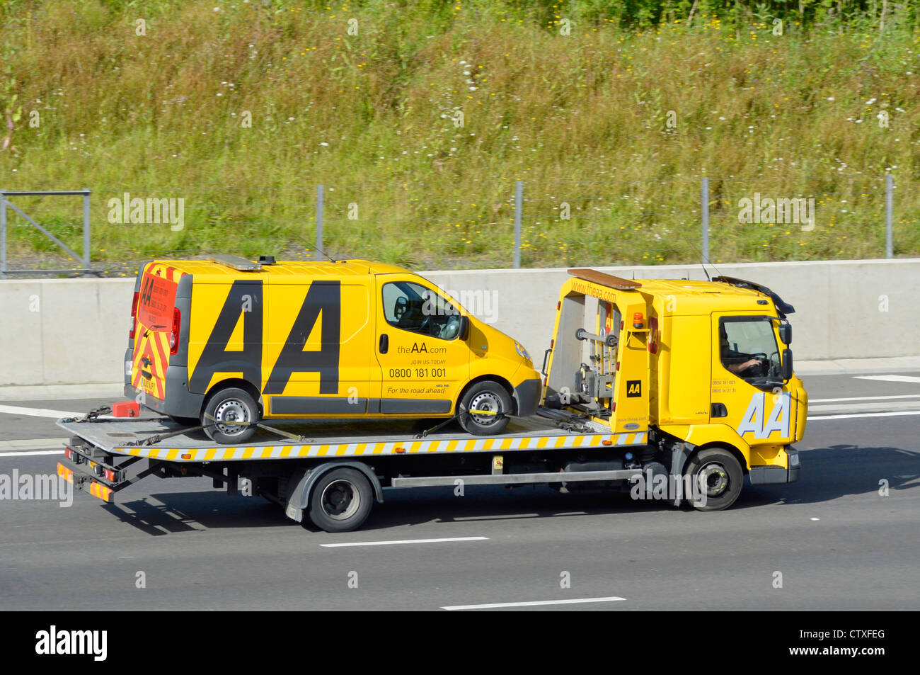 The Automobile Association trading name of AA breakdown rescue services lorry truck loaded with an AA van driving along M25 Motorway Essex England UK Stock Photo