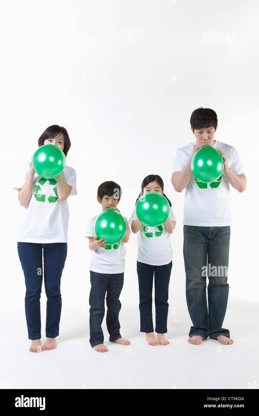 A family blowing green balloons Stock Photo Alamy