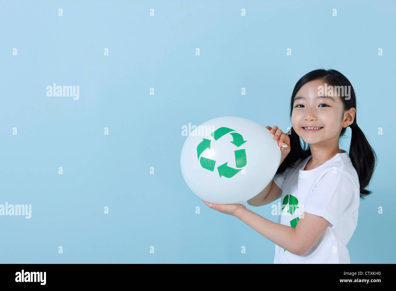 A girl blowing a recycling balloon Stock Photo - Alamy