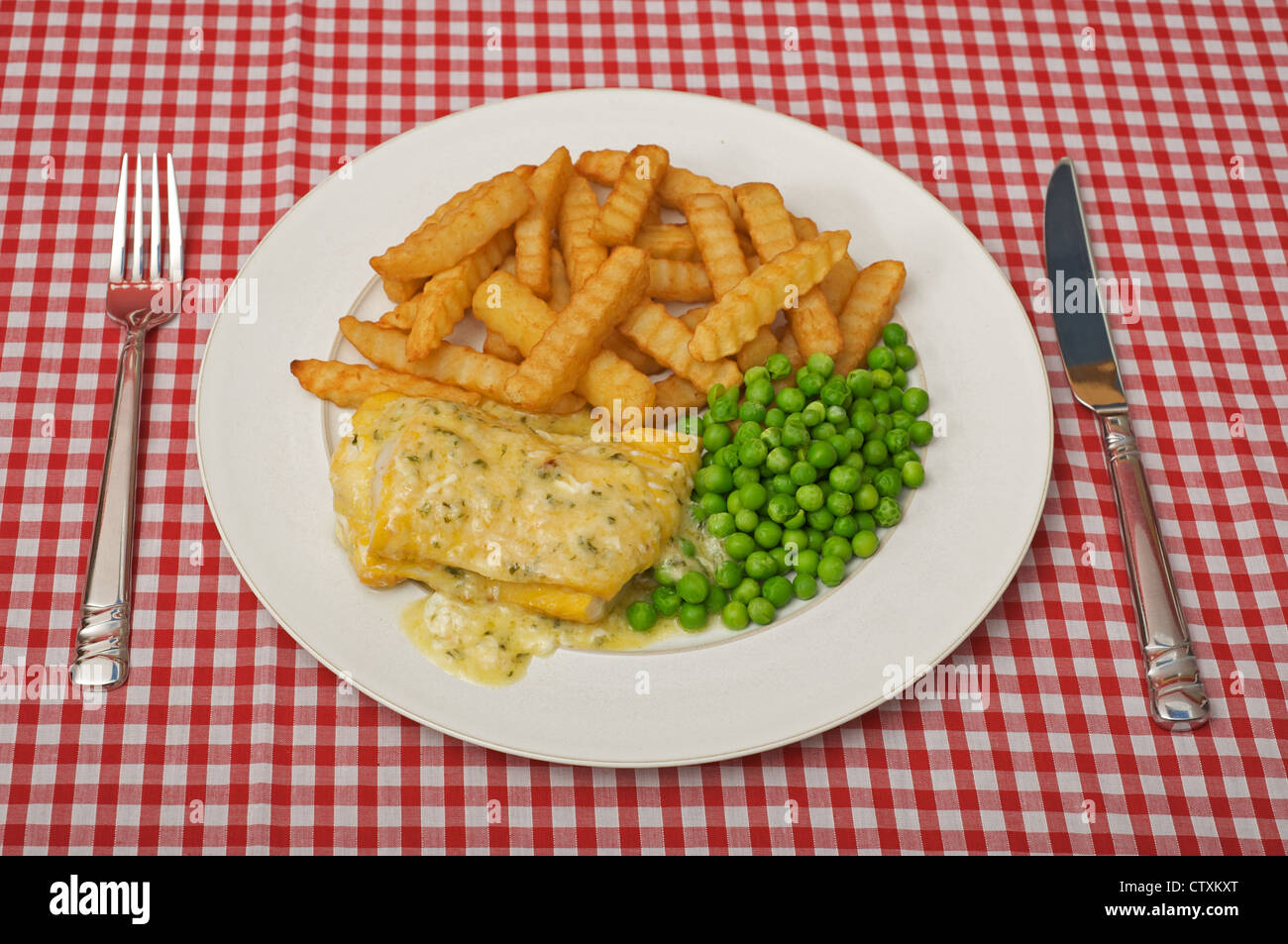 The Saucy Fish Co. Davidstow cheddar and chive sauce on smoked Haddock, chips and peas Stock Photo
