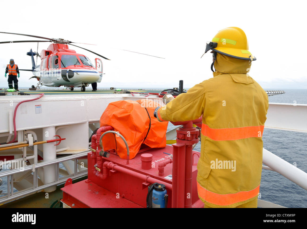 fireman is guarding for offshore helicopter before start up engine. Stock Photo
