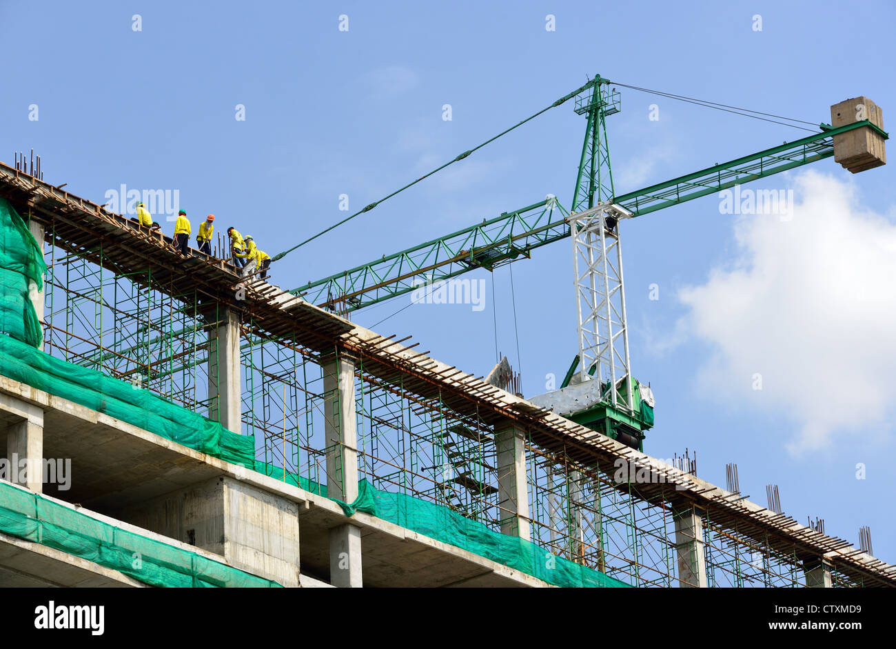 Group of the workers are working on high constructionsite. Stock Photo