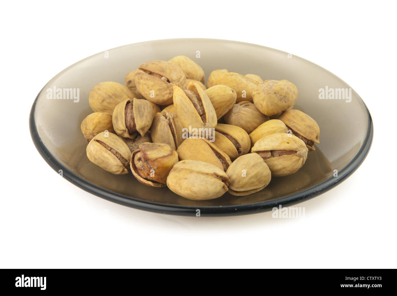 pistachios on a dish are isolated on white Stock Photo