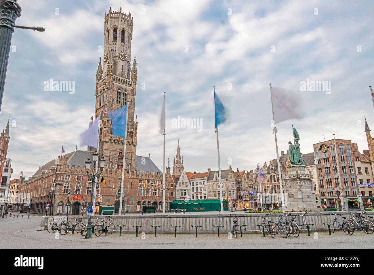 The Belfort, Brugge Market Square with flags flying around a statue of Jan Breydel and Pieter de Coninck Stock Photo