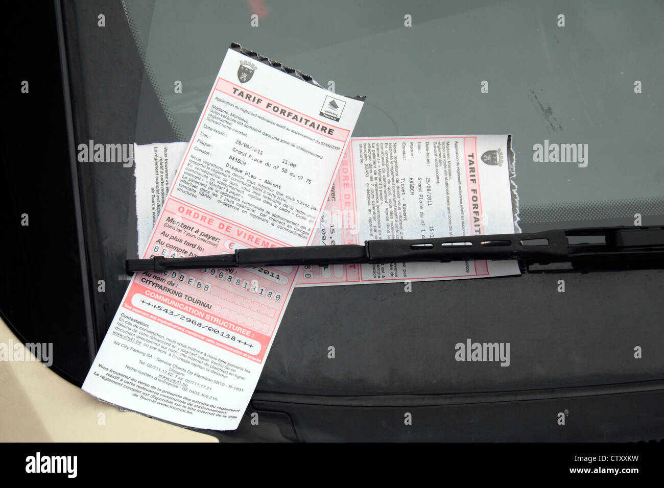 Belgian Tarif forfaitaire (flat rate/fixed penalty) parking tickets on a car windscreen in Tournai, Belgium. Stock Photo