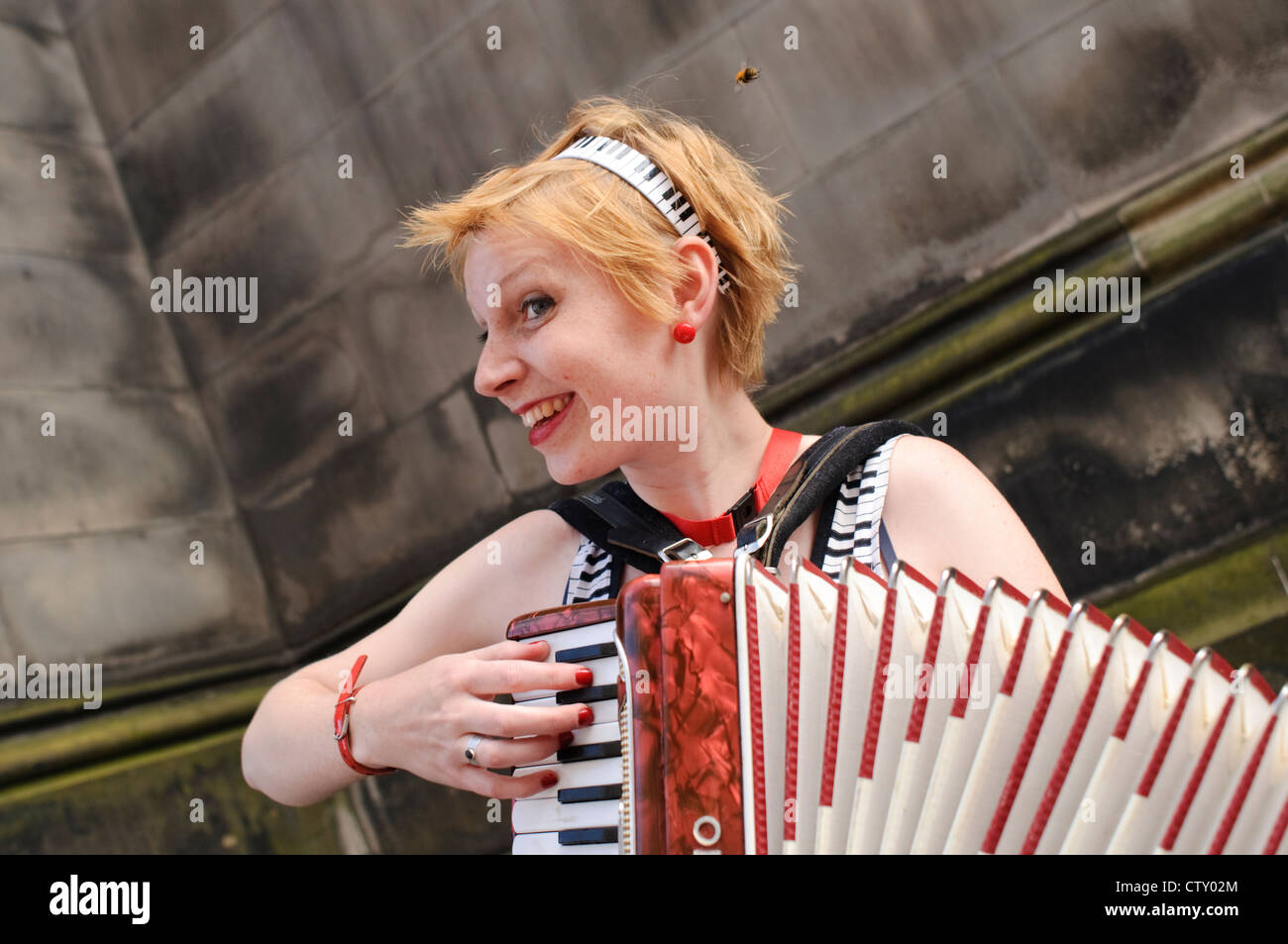 Female accordionist performing on The Royal Mile during the Edinburgh Festival Fringe. Stock Photo