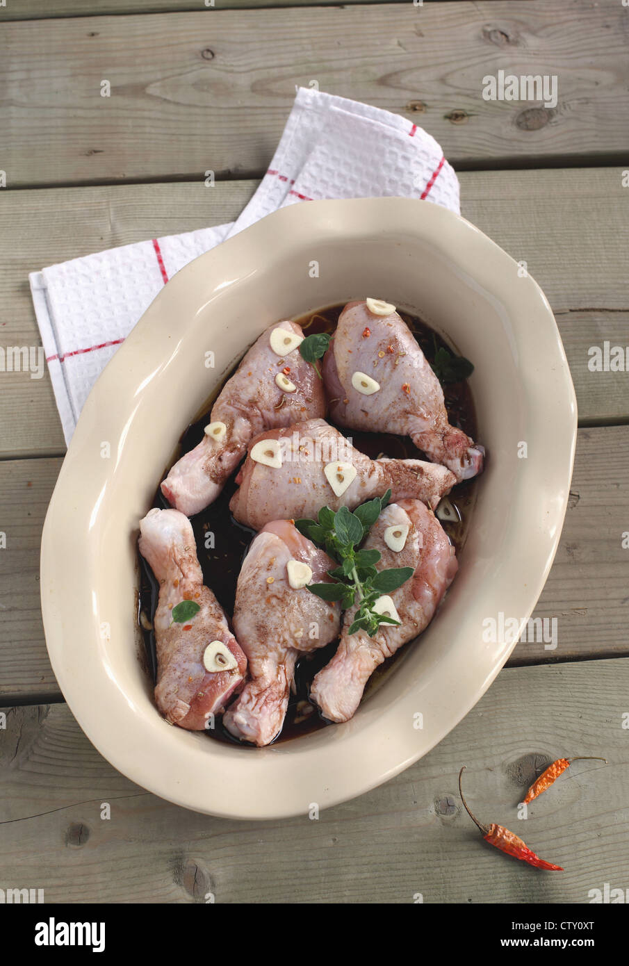 Uncooked chicken in a baking dish with spices Stock Photo