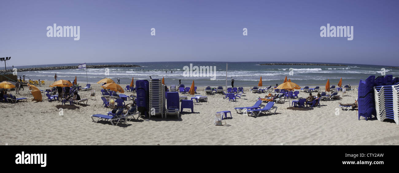 Beach chairs and people relaxing along the coast in Tel Aviv, Israel Stock Photo
