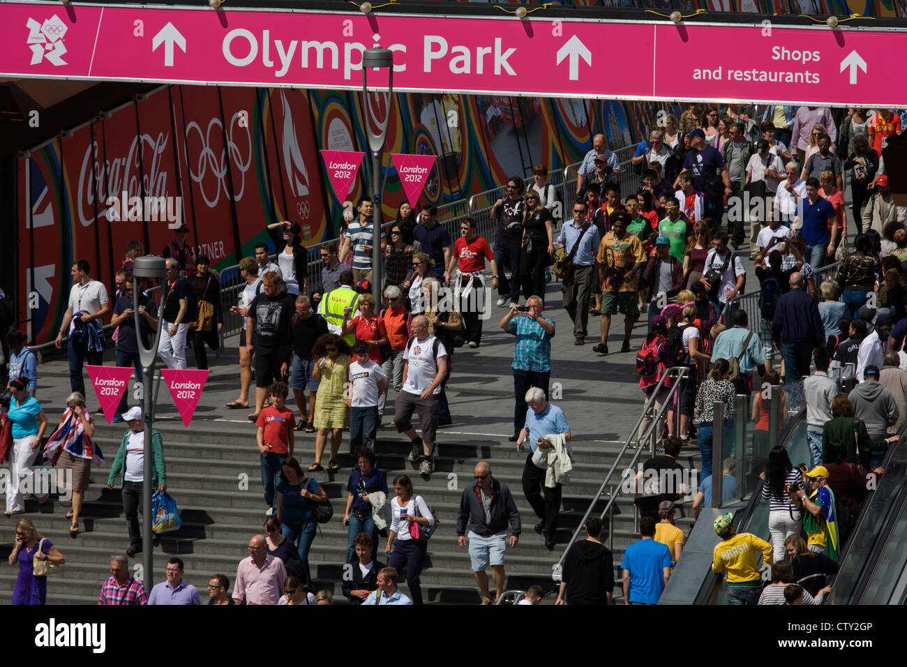 Aerial view of spectator crowds at the Westfield City shopping complex, Stratford that leads to the Olympic Park during the London 2012 Olympics, the 30th Olympiad. Large Coca-Cola ads line the walkway to the Olympic Park. Situated on the fringe of the 2012 Olympic park, Westfield is Europe's largest urban shopping centre. The £1.45bn complex houses more than 300 shops, 70 restaurants, a 14-screen cinema, three hotels, a bowling alley and the UK's largest casino. Stock Photo