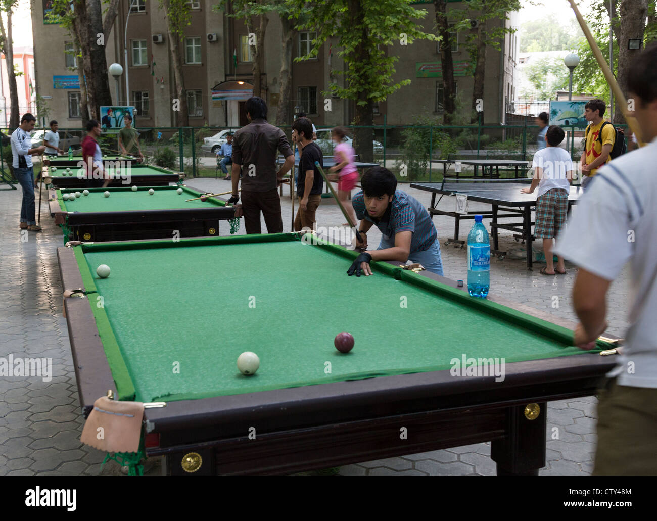 youths playing pool on outdoor tables in Dushanbe, Tajikistan Stock Photo