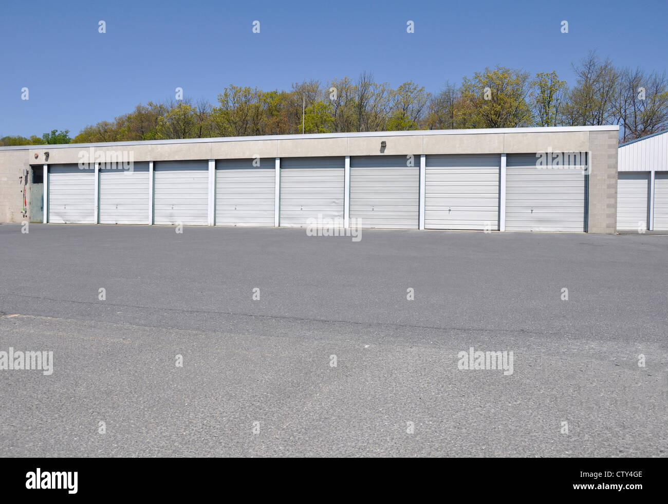 building with many garage doors, which are all closed, by a macadam parking area Stock Photo