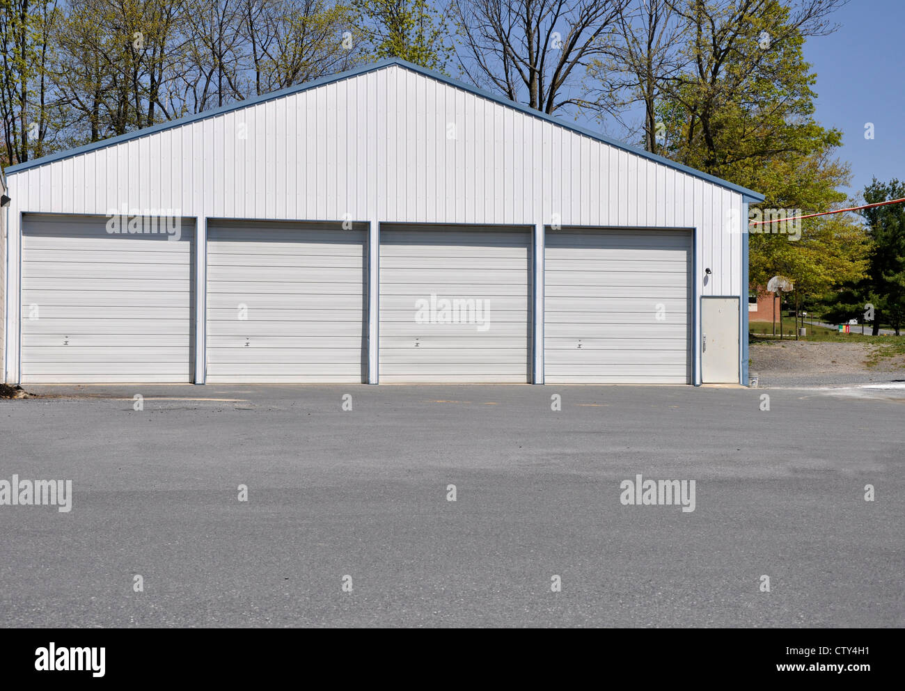 row of garage doors, which are all closed, by a macadam parking lot Stock Photo