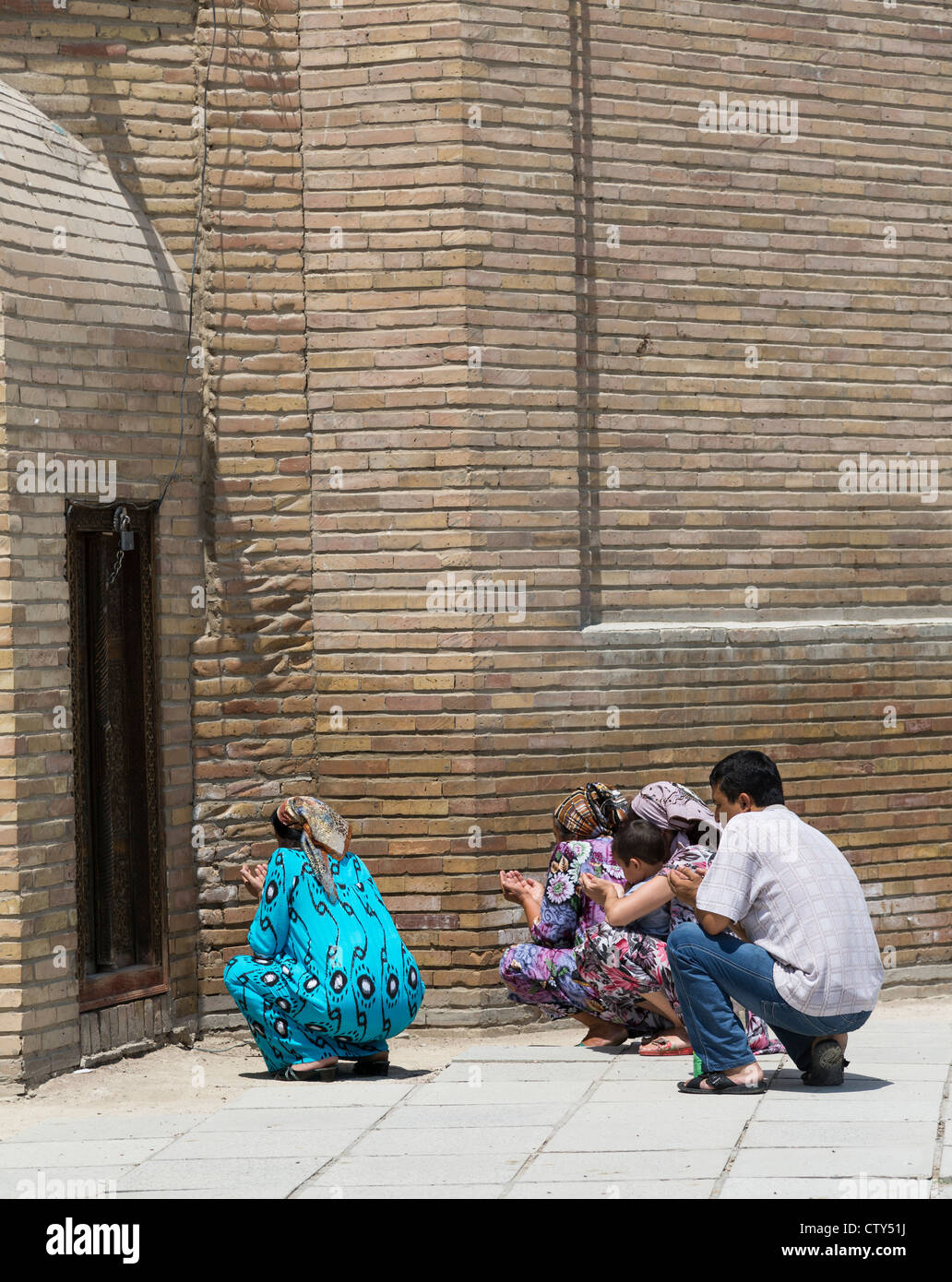 pilgrims in prayer at the tomb of Masal al-Din, Khujand, Tajikistan Stock Photo