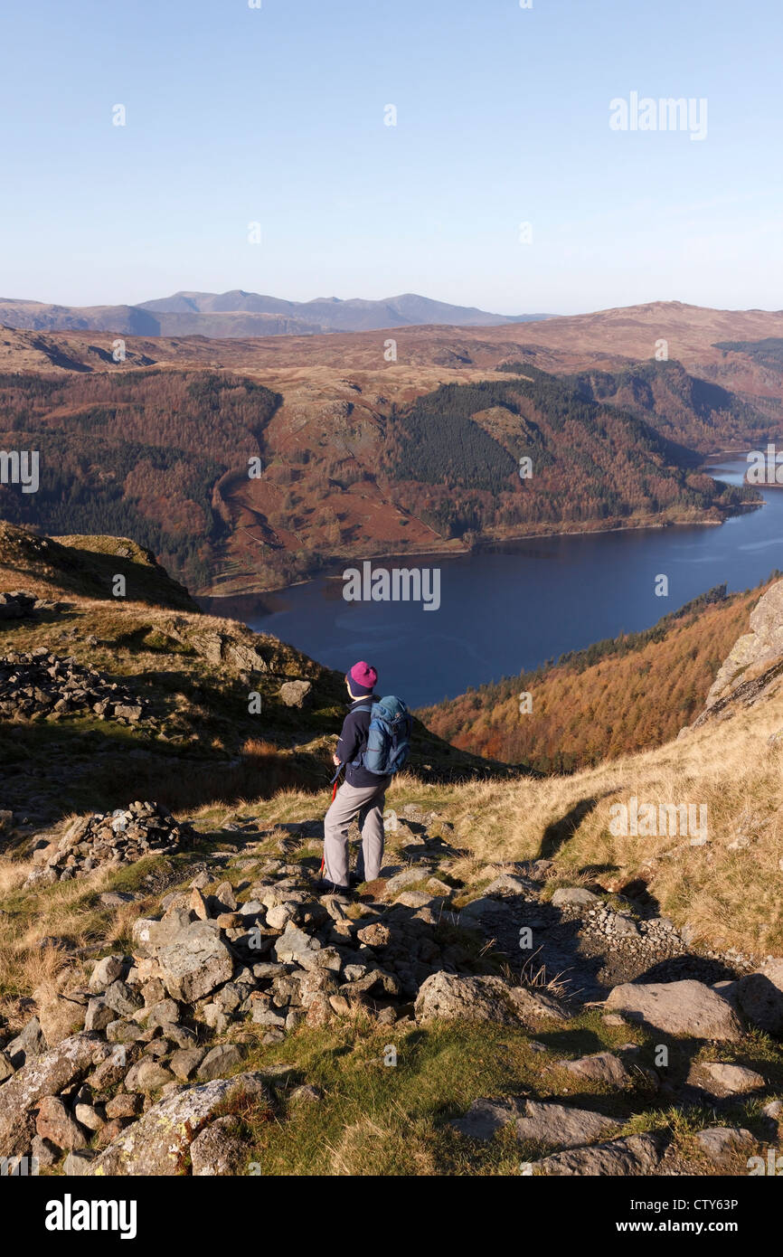 Female hill walker looking down on Thirlmere from the slopes of Helvellyn, Lake District, Cumbria, England, UK Stock Photo