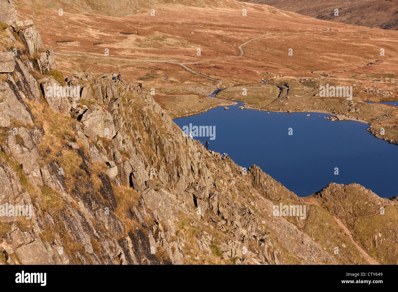 Hill walkers ascending Helvellyn from Striding Edge, Helvellyn, Lake District, Cumbria, England, UK Stock Photo