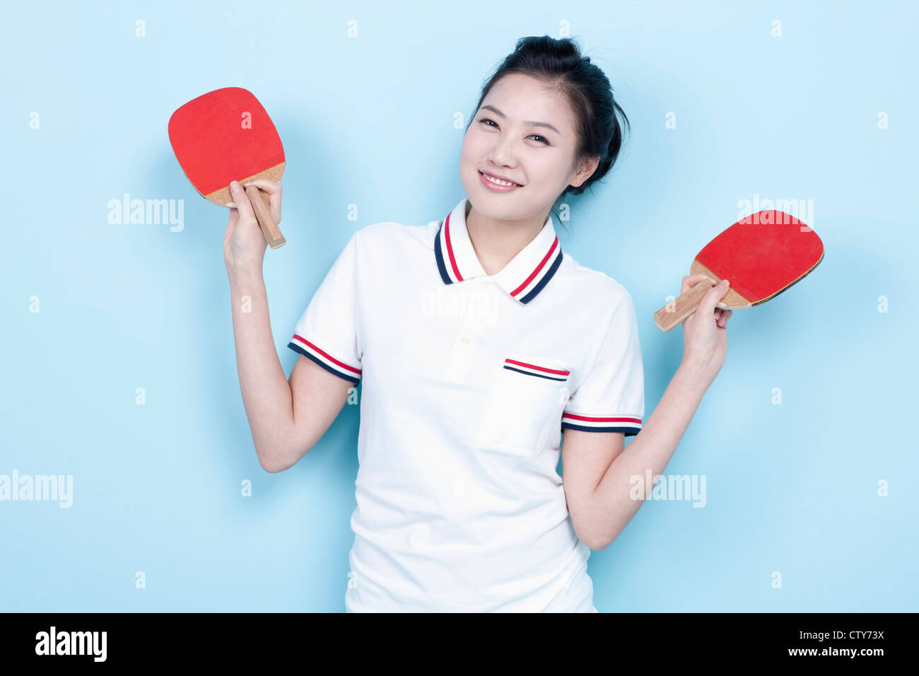 A female ping-pong player with rackets Stock Photo
