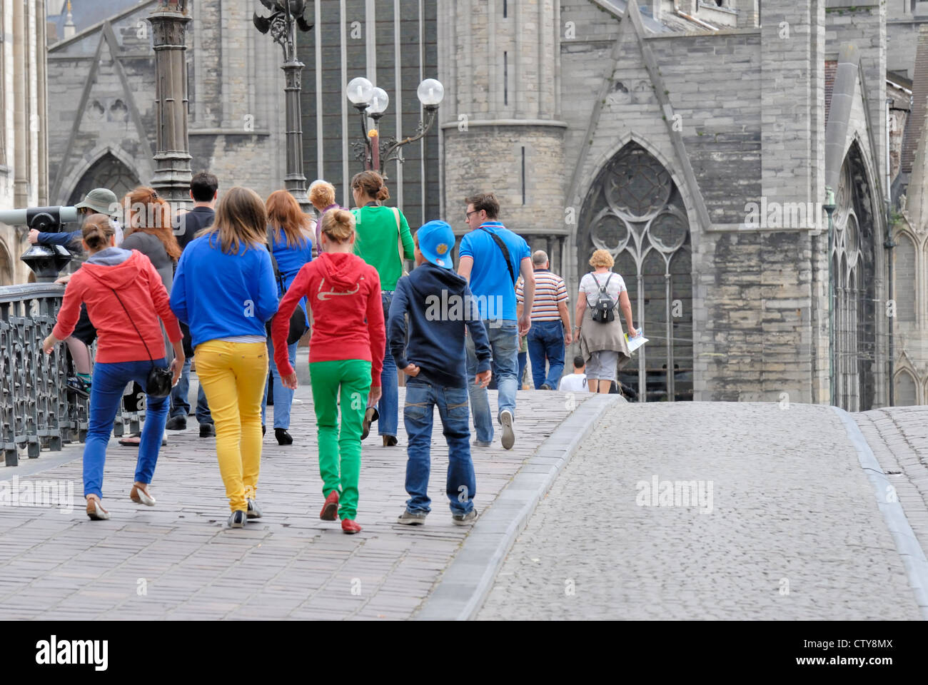 Ghent / Gent, Belgium. Young people crossing Sint Michielsbrug / St Michael's Bridge (1913) in bright colours Stock Photo