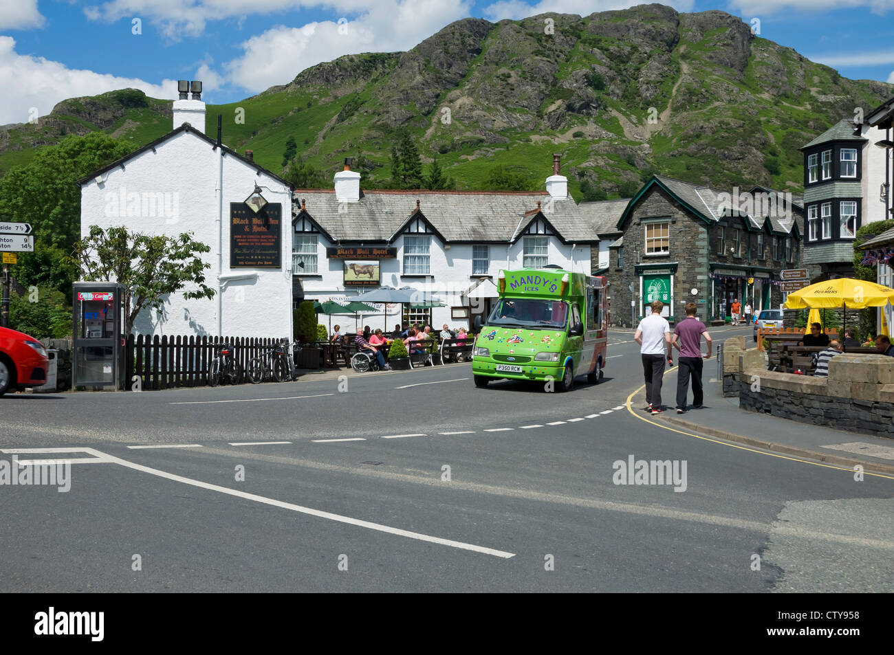 People visitors tourists visiting Coniston village in summer Cumbria England UK United Kingdom GB Great Britain Stock Photo