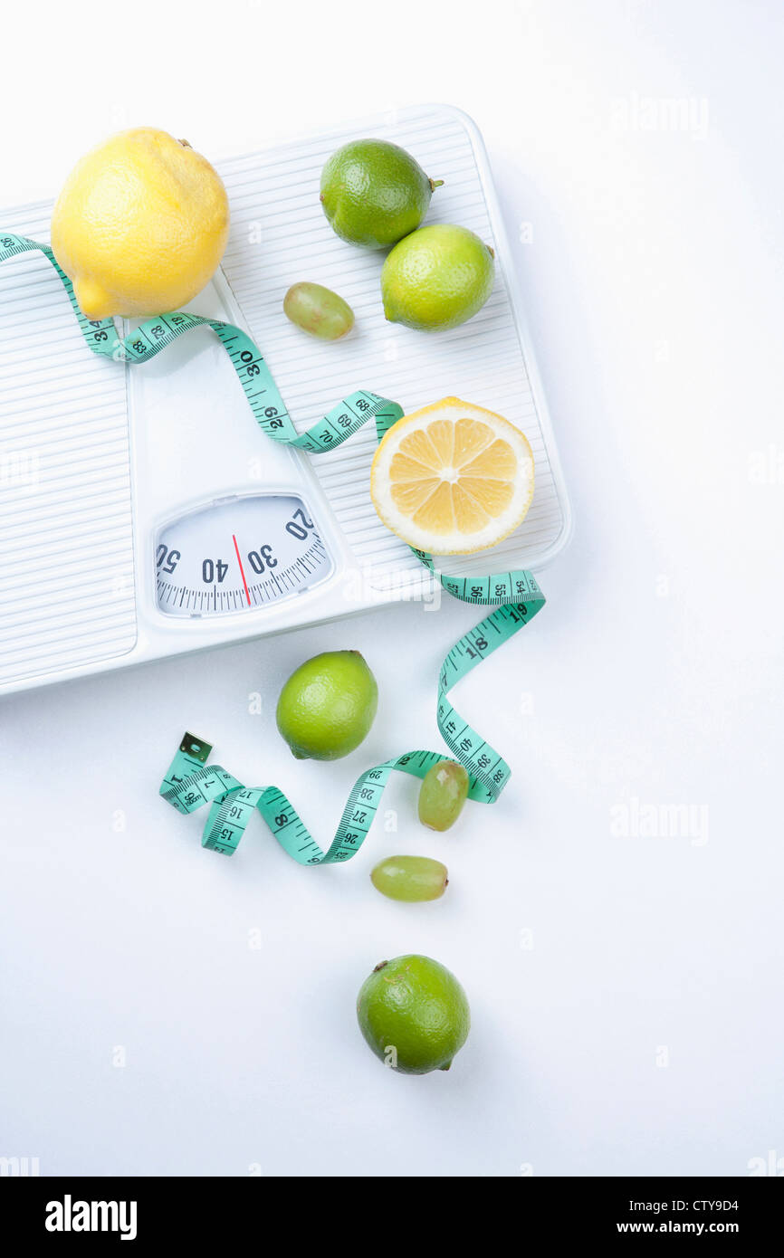 Lemon, lime, and measuring tape on the scale Stock Photo - Alamy