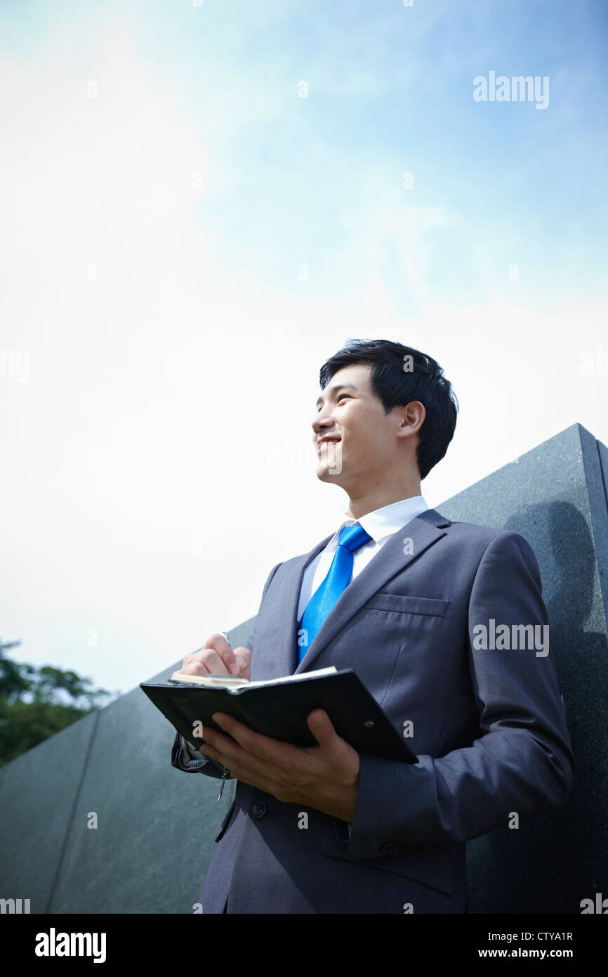 A businessman holding a pen and planner Stock Photo - Alamy