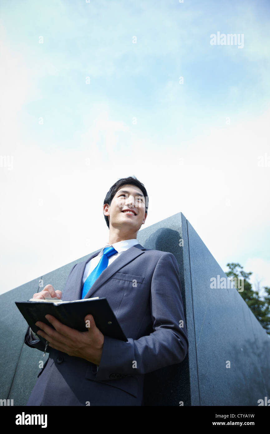 A businessman holding a pen and planner Stock Photo - Alamy