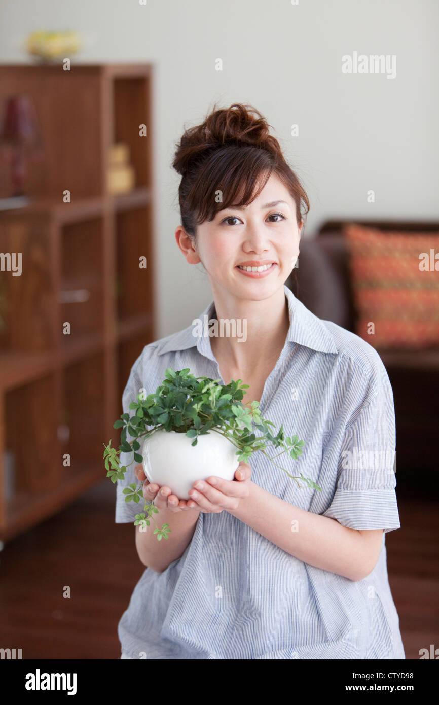 Young woman holding house plant Stock Photo Alamy