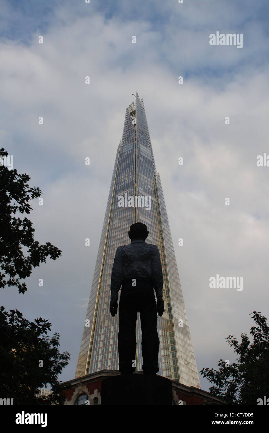 Shard contrasted against human statue Stock Photo