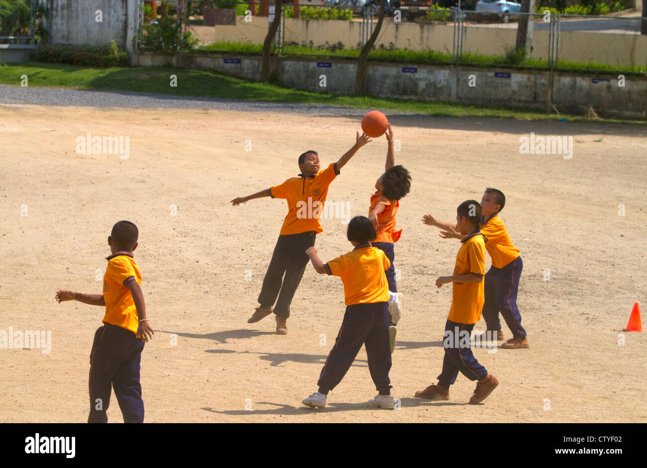 Students play basketball at a Thai elementary school playground on the island of Ko Samui, Thailand. Stock Photo