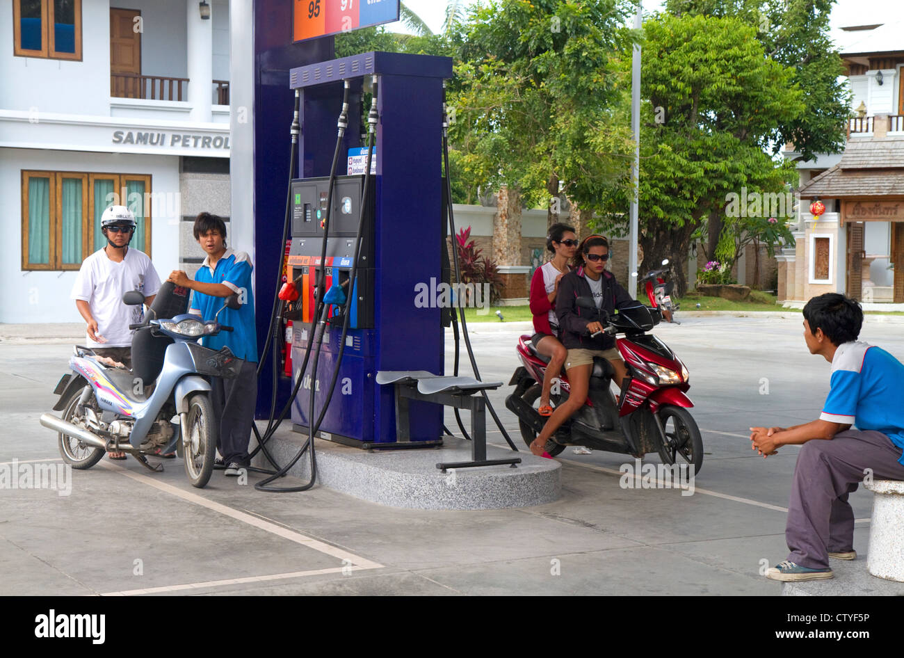Motor scooters fill up at a gas station on the island of Ko Samui