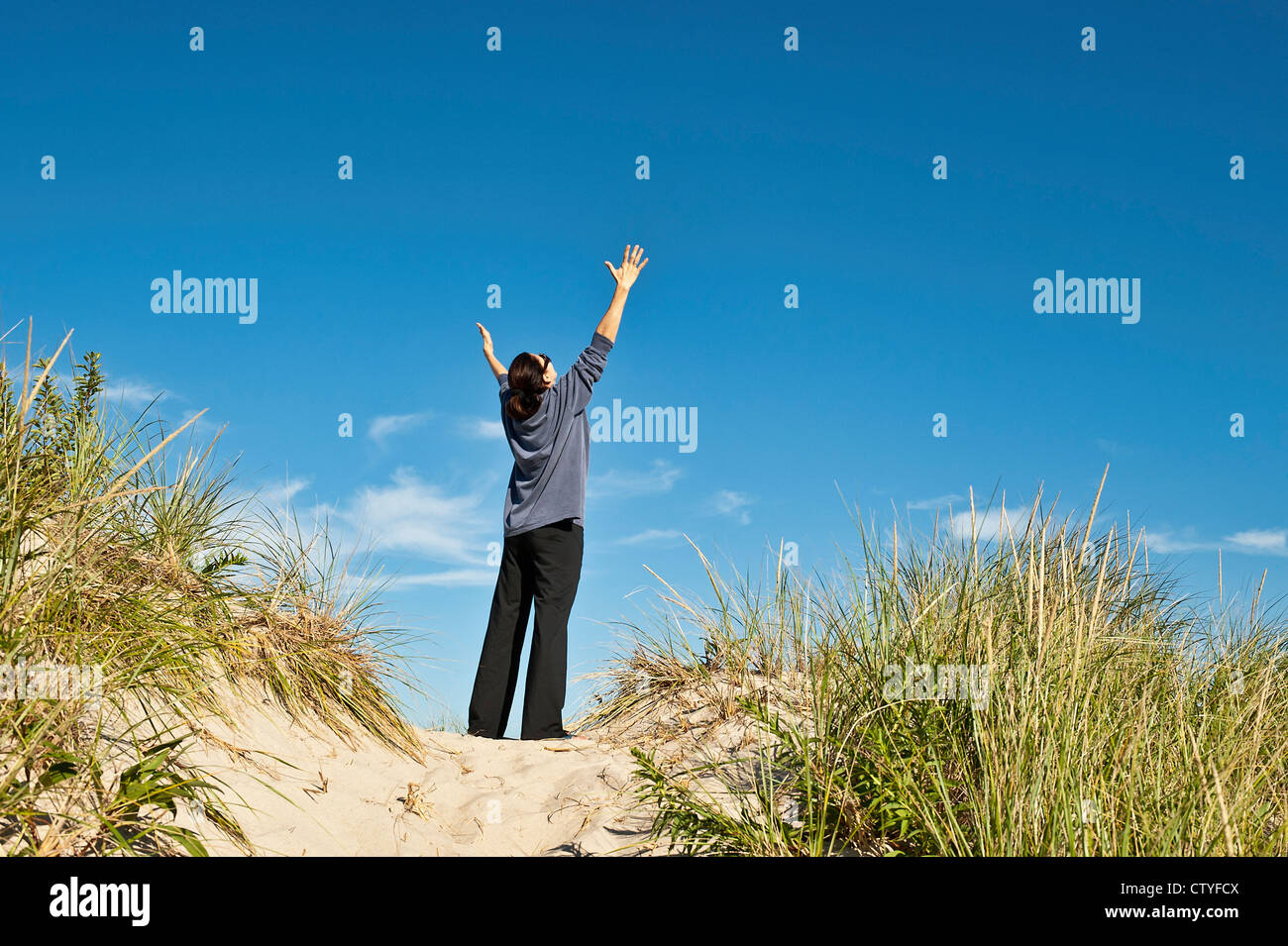 Woman opens her arms in thankful gratitude. Stock Photo