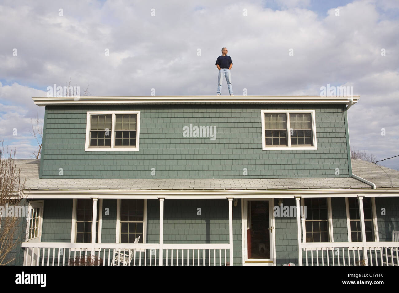 Man on Roof of Home Stock Photo