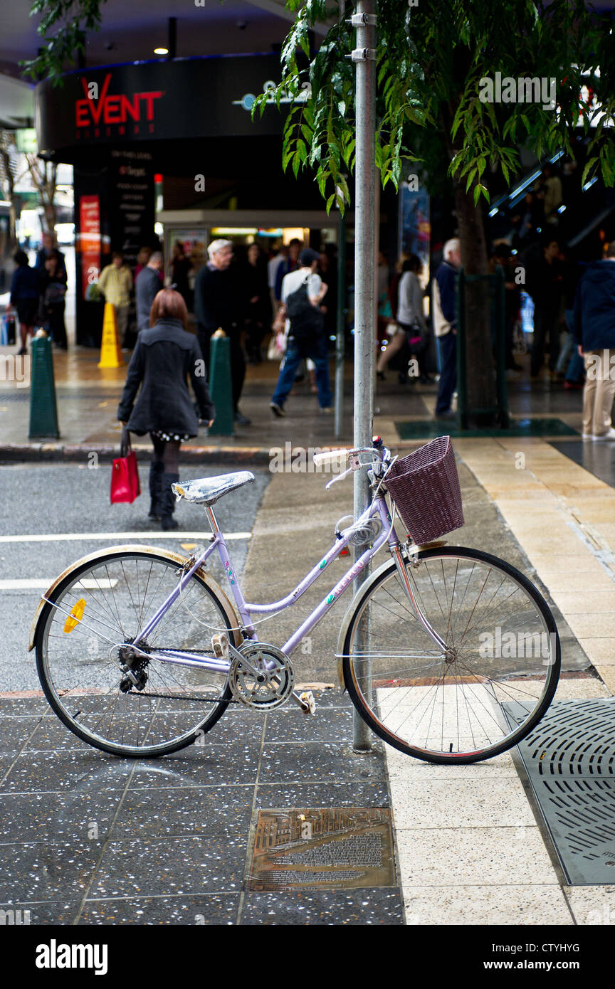 A bicycle leaning against a post on a street in Brisbane, Queensland, Australia. Stock Photo