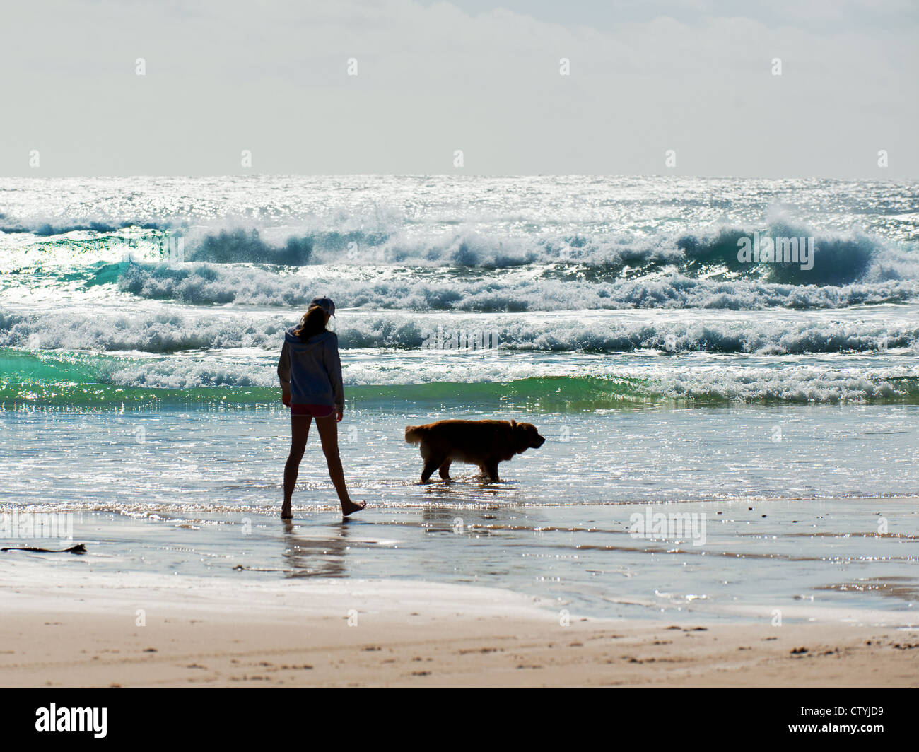A girl and her dog walking on Cylinder Beach on North Stradbroke Island