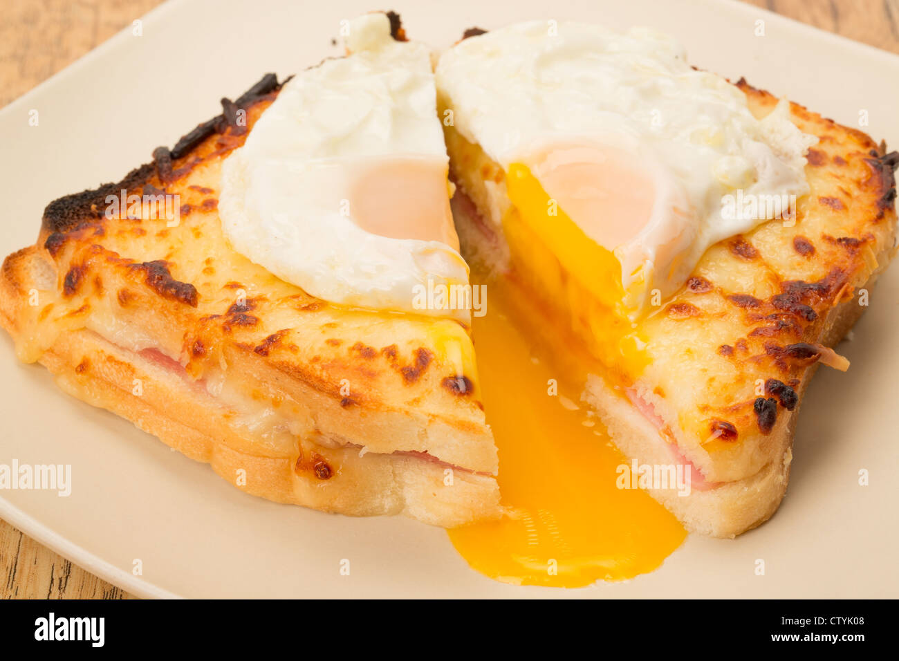 Classic French toasted sandwich or Croque Madame sliced in half with a fried egg on top of the toasted cheese - studio shot Stock Photo