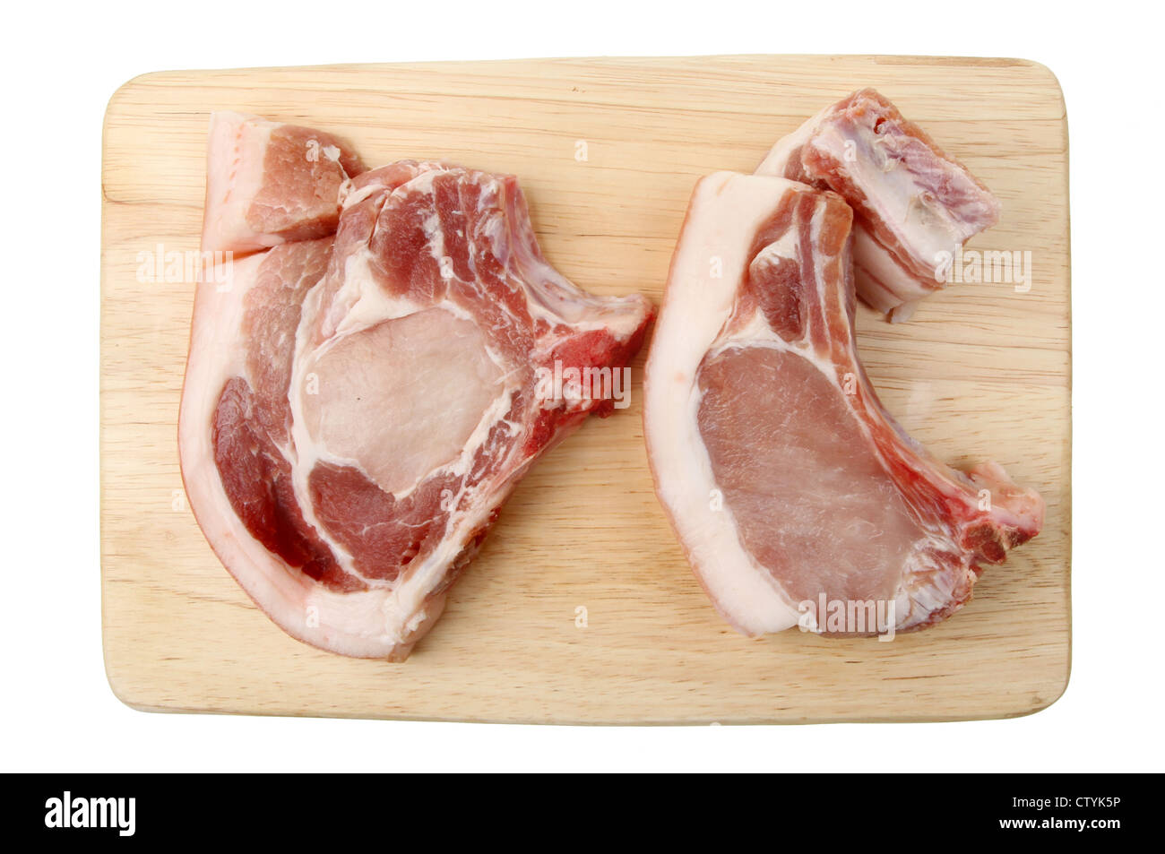 Two raw pork chops on a wooden board photographed from above isolated against white Stock Photo