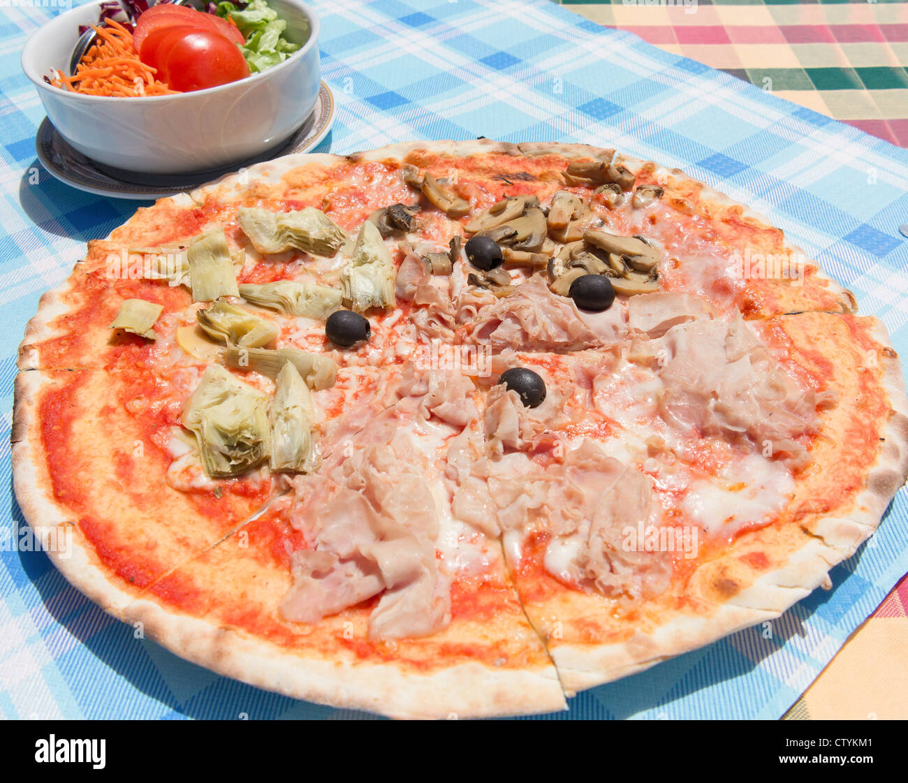 A classic quattro stagioni pizza served outside in a pizzaria restaurant in Italy Stock Photo