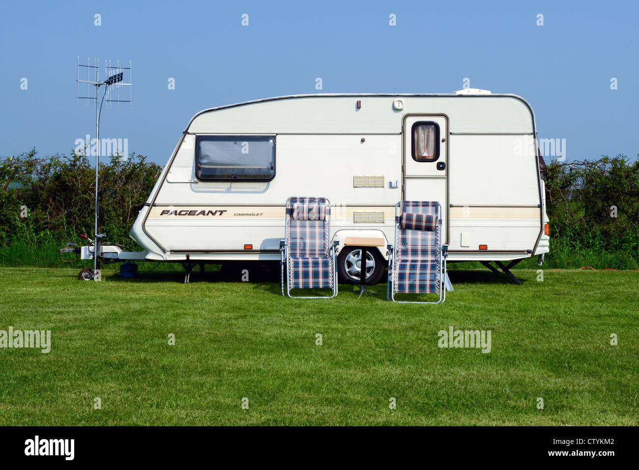 camper van with two sunchairs and tv antenna Stock Photo