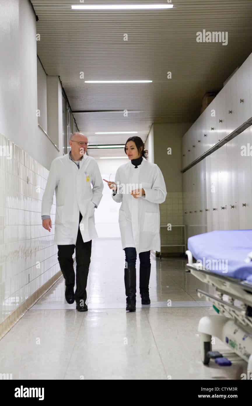 Doctors walk down hospital hallway Stock Photo