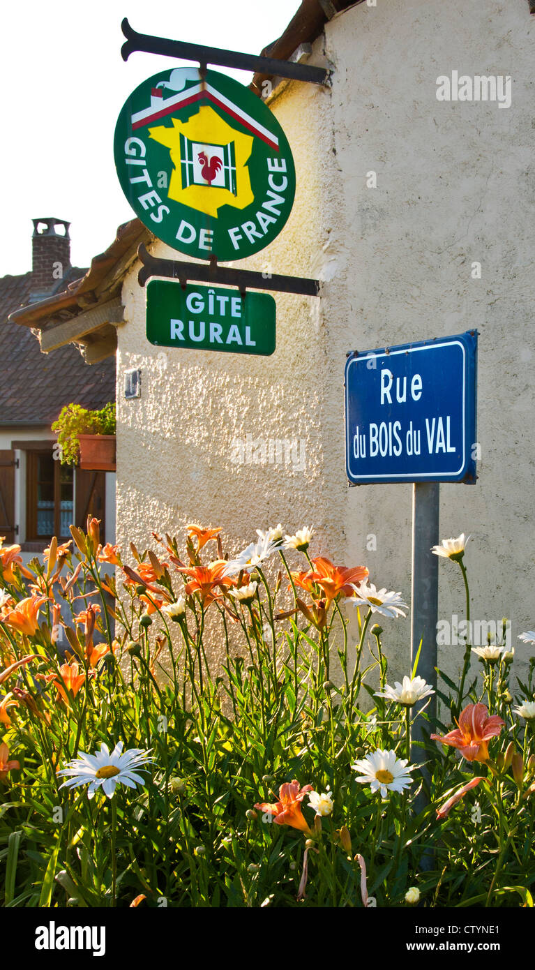 'Gite Rural' sign for bed and breakfast accommodation on cottage in sunny floral French countryside village France Stock Photo