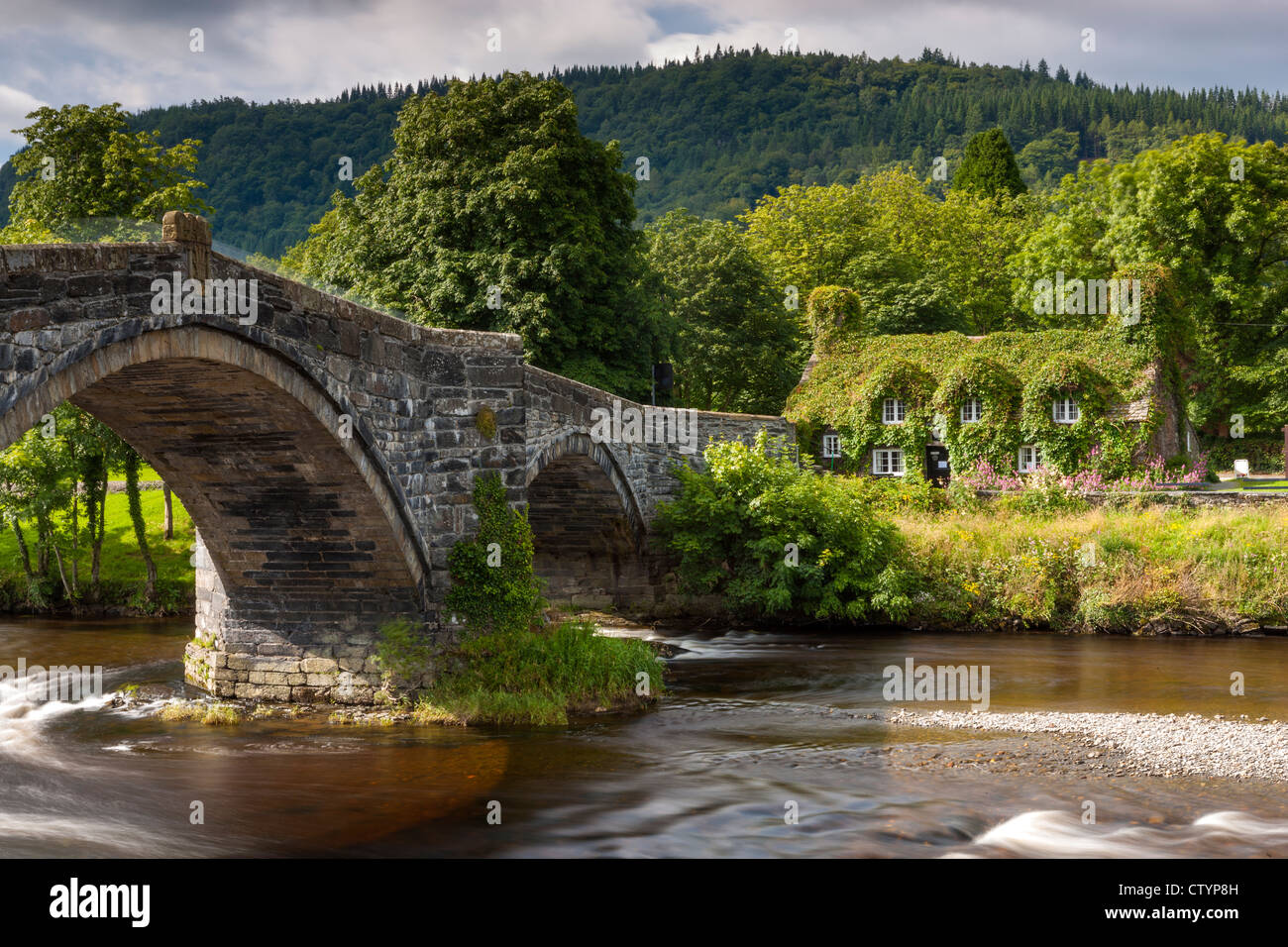 17th century stone bridge over the River Conwy at Llanrwst with the ivy-clad Tu Hwnt i'r Bont National Trust tearooms Stock Photo