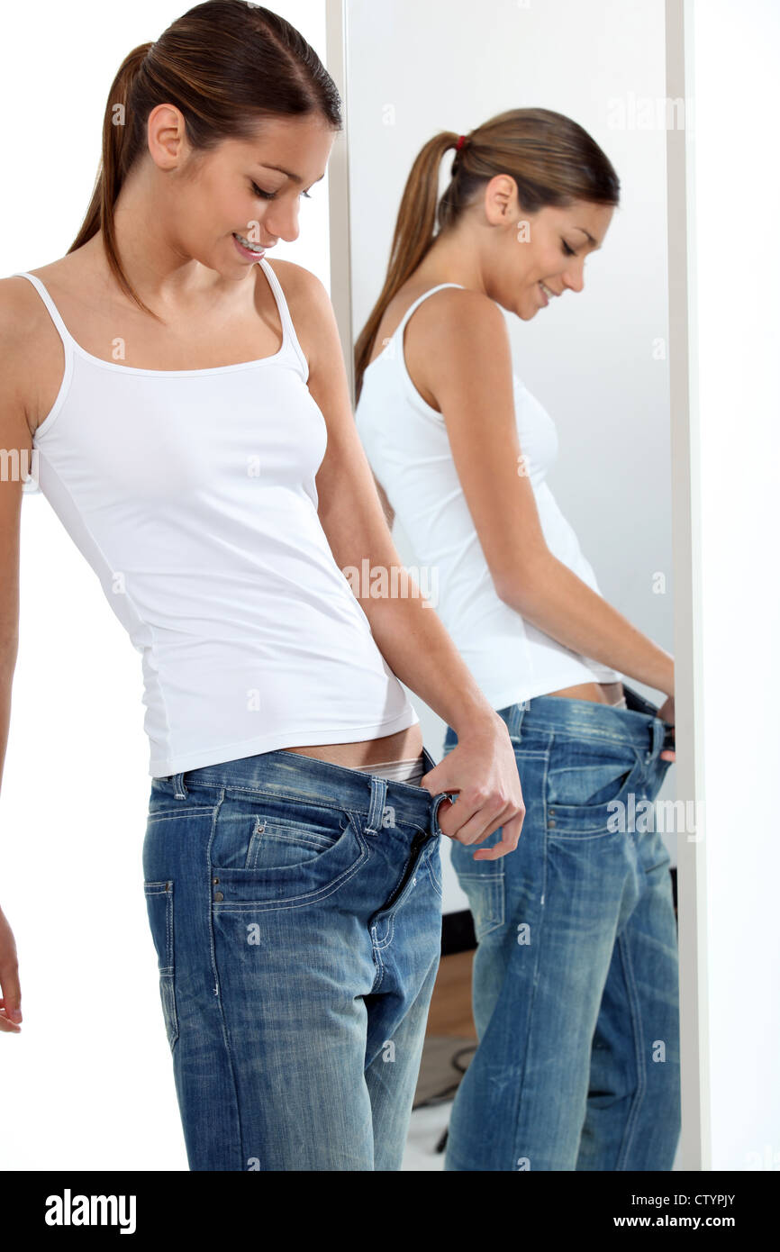 skinny young woman is pulling the top of her jean, too big for her Stock  Photo - Alamy