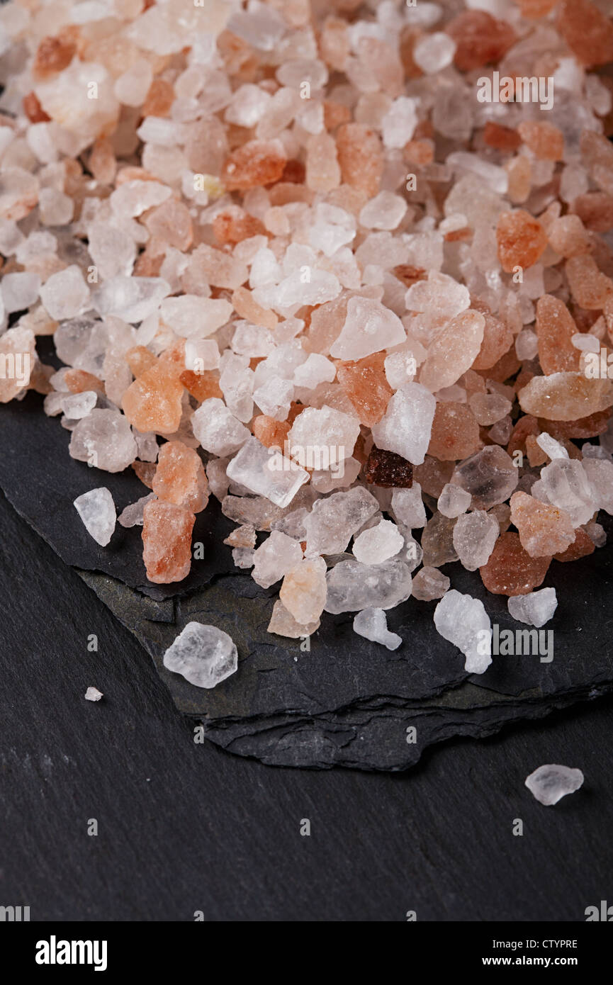 Coarse pink Himalayan, sea salt on black slate stone background