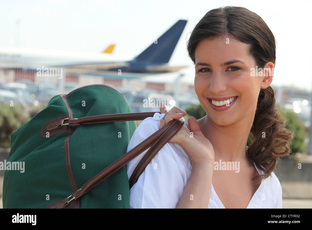 Woman with a travel bag in front of airport Stock Photo