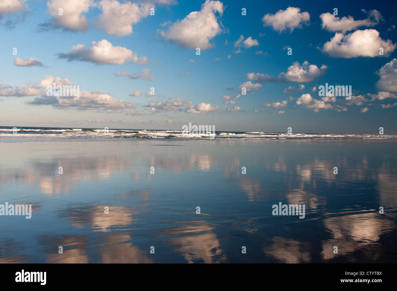 Clouds reflected in water at low tide on Seventy Five Mile Beach, Fraser Island. Stock Photo