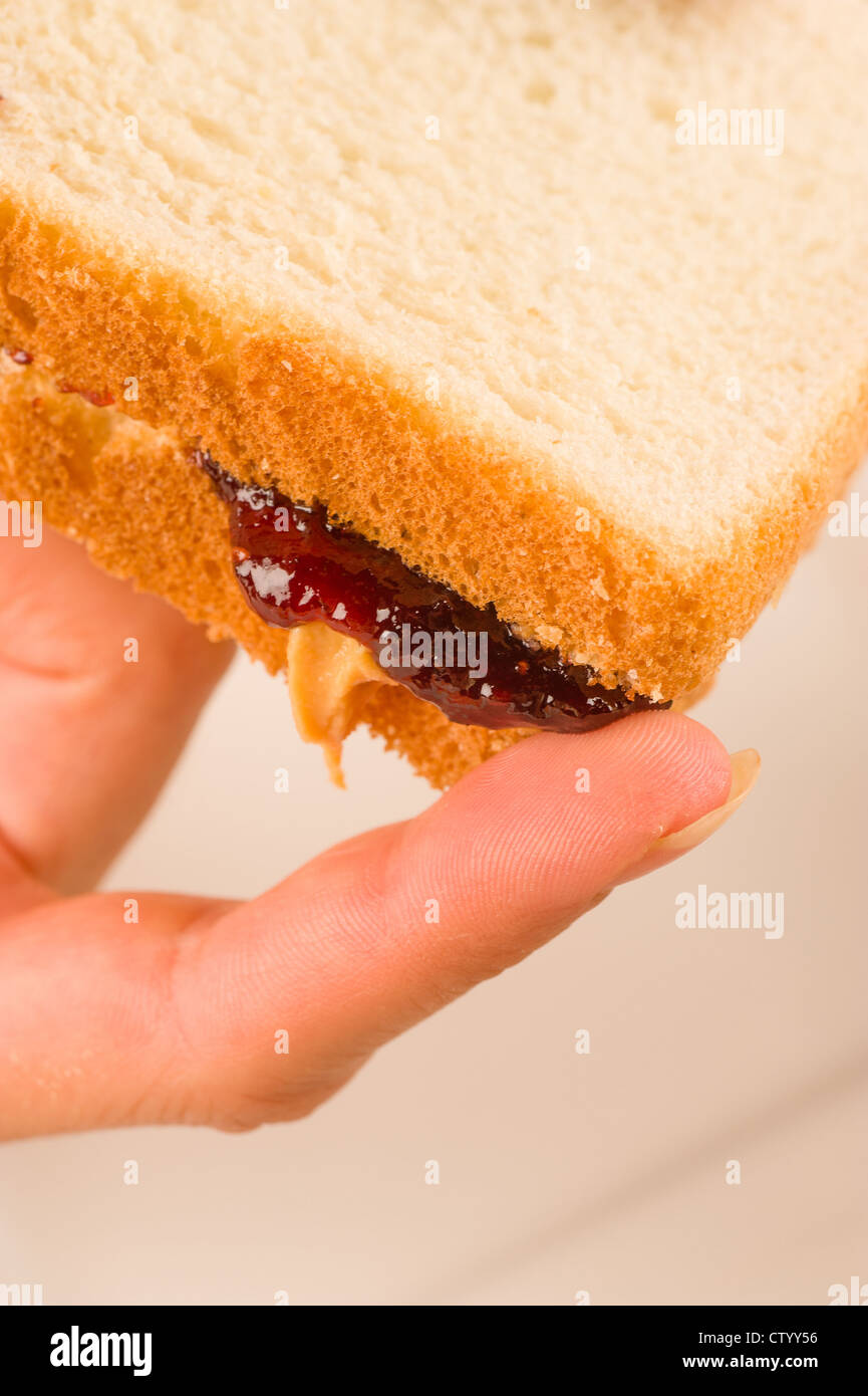 Finger next to dripping peanut butter and jam sandwich Stock Photo Alamy