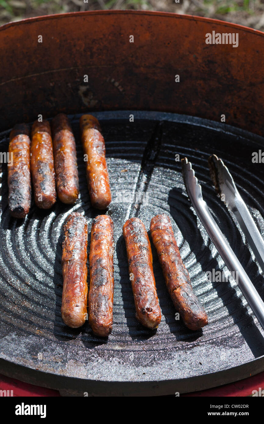 Well done sausages on a small outdoor BBQ hot plate in Australia Stock Photo