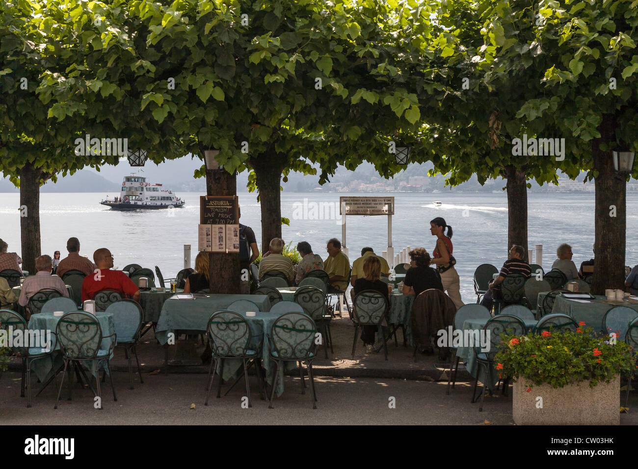 Lakeside cafe/restaurant under trees in Bellagio on Lake Como in Italy Stock Photo